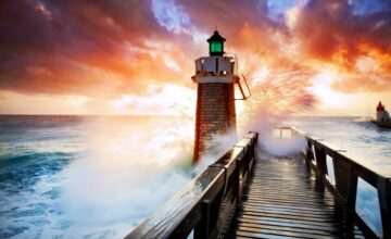 Photo of a light house, stormy sea, and sunrise