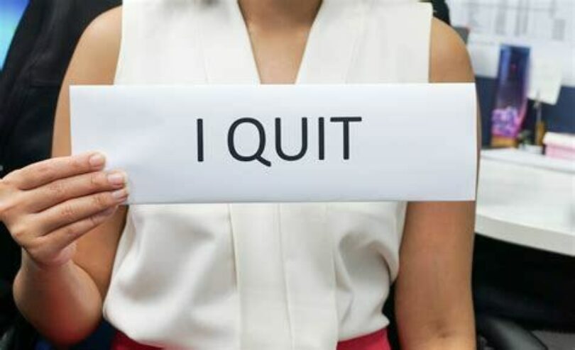 Woman holding sign that says I Quit
